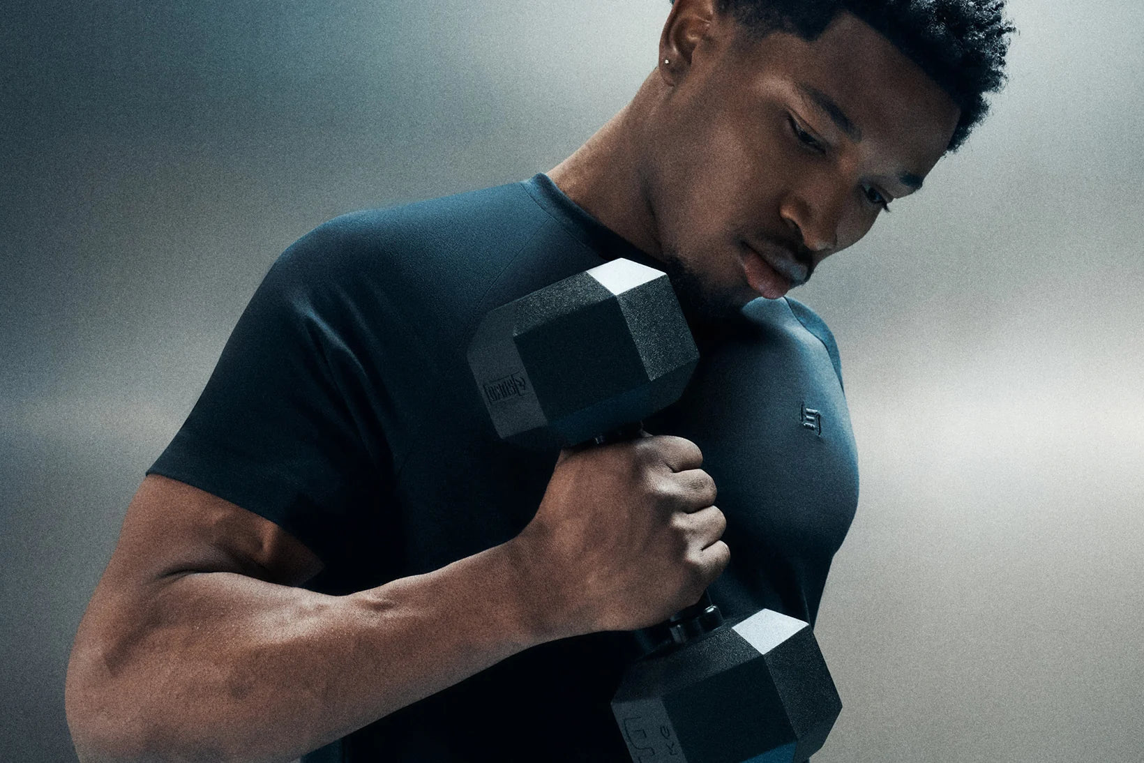 An athlete training with a dumbbell in Echt activewear